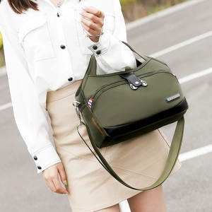 Détail du sac à bandoulière en tissu oxford vert armée avec fermetures éclair et plaque mode