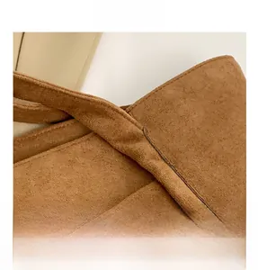 Close-up of the brown velvet tote bag showing stitching details and leather brand label
