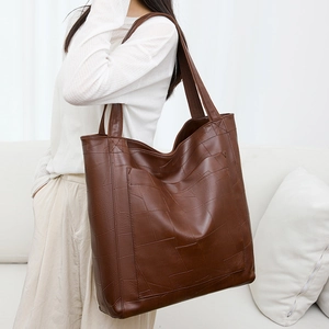 Detailed texture of deep brown PU leather tote bag with geometric stitching design