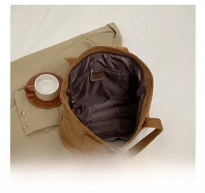 Detail of the brown suede tote bag featuring a spacious interior and a zipped pocket