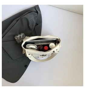 Draufsicht auf das Innere der weißen PU-Ledertasche mit Platz für Gadgets und Kosmetik