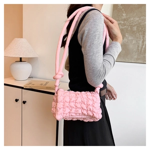 Detail der rosa gesteppten Puff-Schultertasche mit weichem Stoff und Knotengurt-Design
