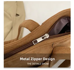 Close-up of silver metal zipper design on brown faux suede shoulder bag with inner lining