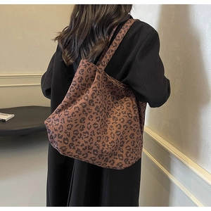 Détail d'un sac cabas en toile à imprimé léopard porté à l'épaule par une femme