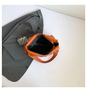 Detailansicht der orangefarbenen PU-Leder-Einkaufstasche mit silberner Schnalle und Stofffutter