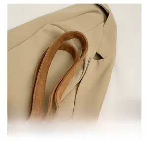 Detail of dark brown faux suede tote bag straps with fine stitching and soft texture