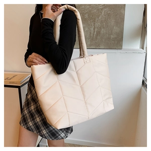 Detail of the chevron quilted nylon texture on this chic cream puffer tote bag