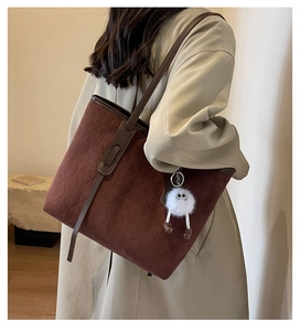 Brown suede tote bag with quilted texture and a cute white plush charm on model