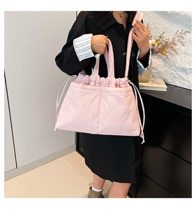 Close-up of pink quilted puffer bag with drawstring closure and soft nylon texture