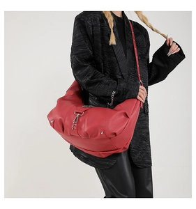 Détail du sac hobo en cuir rouge avec mousqueton argenté et rivets métalliques