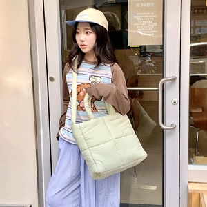 Scatto street style all'aperto di una borsa tote trapuntata verde chiaro per donna capiente