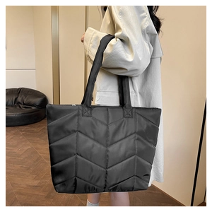 Detail view of the black quilted nylon tote bag featuring classic V-shape stitching pattern