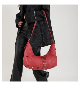 Détail du sac hobo en cuir PU rouge avec croix argentée et décorations à rivets
