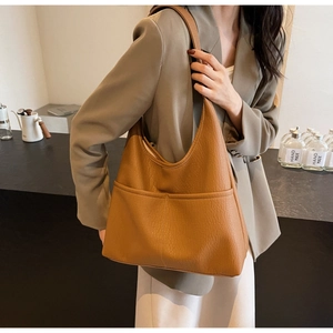 Close-up of brown litchi pattern PU leather tote bag with exterior pocket and wide strap