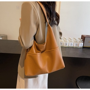 Close-up of pebble grain texture and side pocket on this camel brown PU leather tote bag