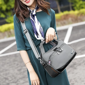 Détail du sac à bandoulière en tissu Oxford gris avec ruban tricolore et zip en métal