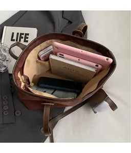 Interior view of large brown velvet tote bag showing spacious storage for tablets and books