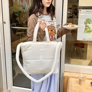 Primo piano della borsa tote trapuntata bianca con consistenza morbida e tracolla