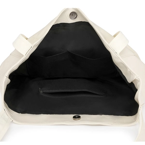 Interior view of off-white quilted tote bag with black lining and secure magnetic buckle