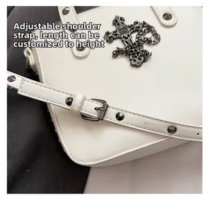 Detail of white PU shoulder bag featuring punk rivets and adjustable buckle strap