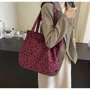 Détail d'un grand sac cabas en tissu à motif léopard bordeaux avec texture souple