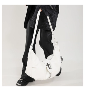 Détail du sac croissant en PU blanc avec croix métallique noire et sangle à œillets