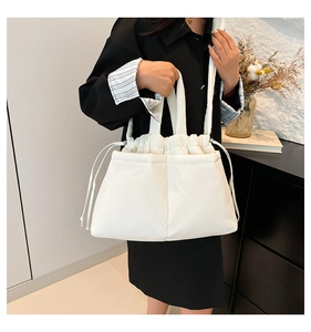 Close-up of a white quilted nylon crossbody bag with adjustable drawstring details