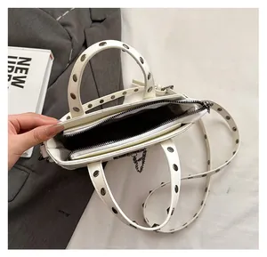 Top view of white PU crossbody bag interior with silver studs and zipper closure