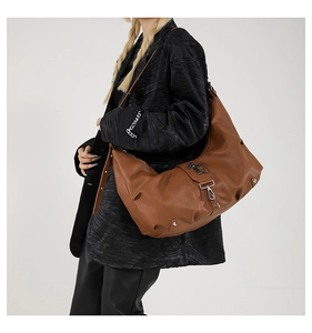 Vue détaillée du sac cabas marron avec croix métalliques gothiques et sangle