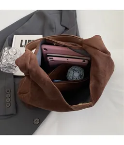 Detail view of spacious inner compartment in brown suede tote bag with zipper pocket