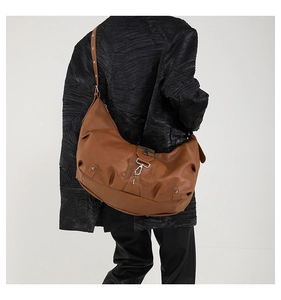 Détail du grand sac bandoulière plissé en similicuir marron avec crochets métalliques argentés