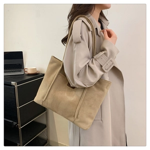 Detail view of khaki corduroy tote bag showing side shoulder strap and front patch pocket