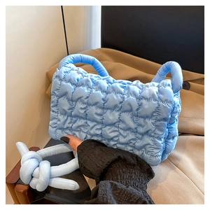 Detail der hellblauen gesteppten Nylon-Handtasche mit Puffy-Wolken-Textur und Knotengriff