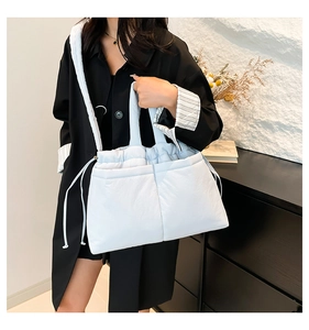 Detailed view of the light blue padded tote bag with drawstring texture and straps