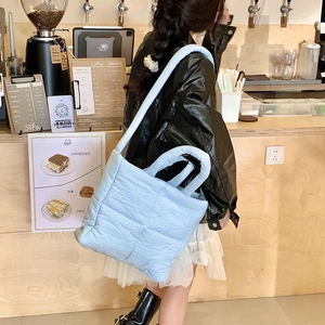 Dettaglio della borsa tote trapuntata celeste con morbida texture in ambiente reale