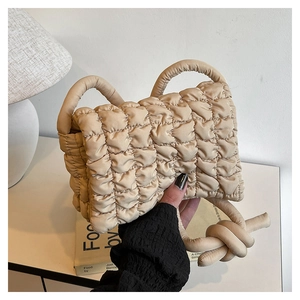 Detailaufnahme der beigen gesteppten Nylon-Handtasche mit einem geknoteten Schulterriemen