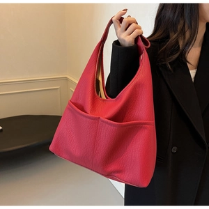 Detailed view of magenta lychee-grain PU leather tote bag with functional front pockets