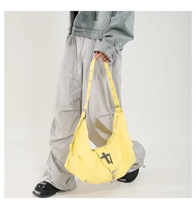 Détail d'un sac Hobo en cuir PU jaune vif avec boucle croix argentée et chaîne