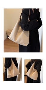 Detail of a large hobo tote bag in beige suede with a brown leather shoulder strap
