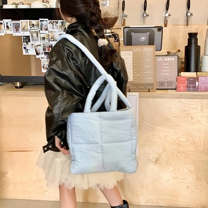 Vista in stile street della borsa tote trapuntata celeste con design a trama gonfia