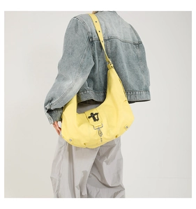 Détail d'un sac Hobo en cuir PU jaune vif avec un fermoir en métal noir unique et des boucles