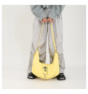 Détail du sac Hobo jaune en cuir PU avec pendentif croix métallique et large sangle