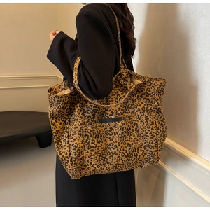 Gros plan d'un sac cabas en toile à motif léopard avec poignées et poche extérieure