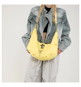 Détail du sac hobo en cuir PU jaune avec boucle en métal croix argentée et bandoulière réglable