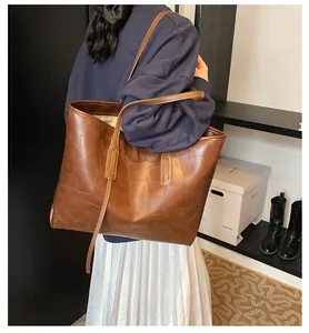 Detailed view of vintage brown PU tote bag with unique patchwork texture and long shoulder straps