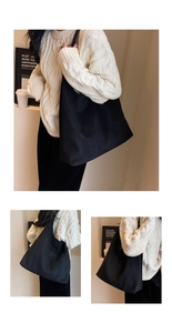 Macro view of large black fabric tote bag with soft texture and wide shoulder strap