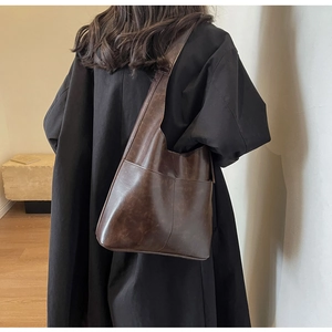 Detail view of brown vintage PU leather shoulder bag with functional dual front pockets