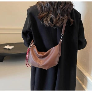 Minimalist brown PU leather crescent hobo bag styled with a black coat for women