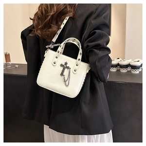 Detail view of white PU leather crossbody bag featuring gothic cross and chain with metal studs