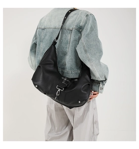 Vue détaillée d'un grand sac hobo en similicuir noir avec garnitures argentées sur un modèle
